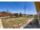Backyard shows a wooden deck, overgrown grass, a brick border, and a view of neighboring buildings at 7146 Jennie Dr, Denver, CO 80221