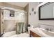 Modern bathroom with tiled walls, glass shower door, and a sink with a wooden vanity at 7146 Jennie Dr, Denver, CO 80221