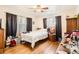 Bedroom with hardwood floors, ceiling fan, and windows dressed with patterned curtains at 7146 Jennie Dr, Denver, CO 80221