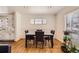Bright dining room featuring hardwood floors, a modern table set, and a window with natural light at 7146 Jennie Dr, Denver, CO 80221