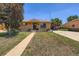 Charming brick home featuring a well-kept front lawn, covered parking, and welcoming curb appeal on a sunny day at 7146 Jennie Dr, Denver, CO 80221