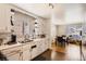 Well-lit kitchen with bright white cabinets and subway tile backsplash opens to a dining area, creating a functional layout at 7146 Jennie Dr, Denver, CO 80221