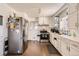 Spacious kitchen featuring white cabinetry, stainless steel appliances, and plenty of counter space for meal preparation at 7146 Jennie Dr, Denver, CO 80221