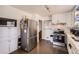 Bright kitchen with stainless steel appliances, white cabinetry, and dark tiled floors, creating a functional cooking space at 7146 Jennie Dr, Denver, CO 80221