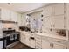 Well-lit kitchen with bright white cabinets, stainless steel appliances, subway tile backsplash, and ample counter space at 7146 Jennie Dr, Denver, CO 80221