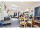 Spacious living room featuring carpet, brick-accented wall, skylights, a table with chairs, and a sofa at 7146 Jennie Dr, Denver, CO 80221