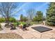 Landscaped backyard with a stone patio, fire pit, hot tub, and lush greenery for outdoor enjoyment at 7390 Sagebrush Dr, Parker, CO 80138