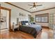 Well-lit bedroom with hardwood floors, modern decor, and a view to a closet through an arched doorway at 7390 Sagebrush Dr, Parker, CO 80138