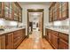 Butler's pantry featuring granite countertops, custom wood cabinetry and a long corridor to the kitchen at 7390 Sagebrush Dr, Parker, CO 80138