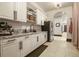 Butler's pantry features white cabinets, granite counters, stainless fridge, and access to other rooms at 7390 Sagebrush Dr, Parker, CO 80138