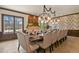 Elegant dining room features a long table with upholstered chairs and a decorative fireplace with beautiful chandelier at 7390 Sagebrush Dr, Parker, CO 80138