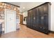 Hallway with large custom storage cabinets, tile floors, access to other rooms and security door at 7390 Sagebrush Dr, Parker, CO 80138