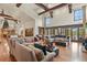 Open living room with hardwood floors, large windows, and a grand stone fireplace at 7390 Sagebrush Dr, Parker, CO 80138