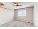 Neutral carpeted bedroom with shelving and ceiling fan at 5540 Palomino Way, Frederick, CO 80504