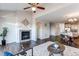 Bright living room featuring a fireplace, wood floors, and an open floor plan with a ceiling fan at 5540 Palomino Way, Frederick, CO 80504