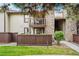 Inviting condo exterior with stone accents, second story balcony, and charming wood fence at 7710 W 87Th Dr # K, Arvada, CO 80005