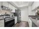 Well-equipped kitchen with stainless steel appliances, a sleek range hood, and stylish backsplash at 7710 W 87Th Dr # K, Arvada, CO 80005