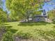 Large, grassy backyard with mature trees and a fenced perimeter at 4196 S Reading Way, Denver, CO 80237