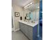 Bathroom with dual sinks, shaker cabinets, quartz counters, and a large framed mirror at 4196 S Reading Way, Denver, CO 80237
