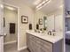 A primary bathroom with double sinks, gray vanity, and a framed mirror is showcased at 4196 S Reading Way, Denver, CO 80237
