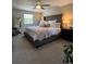 Comfortable primary bedroom featuring a tufted headboard, ceiling fan and an abundance of natural light at 4196 S Reading Way, Denver, CO 80237