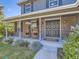 Inviting front porch with rocking chairs, brick facade, and well-maintained landscaping at 4196 S Reading Way, Denver, CO 80237
