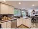 Well-lit kitchen featuring stainless appliances, white cabinetry, and a view into the dining area at 4196 S Reading Way, Denver, CO 80237