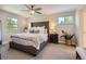 This main bedroom features a tufted headboard, a ceiling fan, and windows for natural light at 4196 S Reading Way, Denver, CO 80237