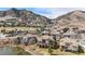 Picturesque aerial shot showcases this home's premium lot near a tranquil pond and beautiful mountain views at 16323 River Haven Way, Morrison, CO 80465