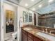 This bathroom features a double vanity with granite countertop, two sinks and a walk-in shower at 16323 River Haven Way, Morrison, CO 80465