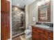 Bathroom featuring a tiled glass shower enclosure, decorative vanity, and cabinet for storage at 16323 River Haven Way, Morrison, CO 80465