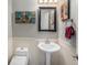 This charming bathroom features a pedestal sink, a black framed mirror and decorative art at 16323 River Haven Way, Morrison, CO 80465