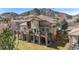 Expansive two-story home featuring multiple balconies, stone accents, and mountain views at 16323 River Haven Way, Morrison, CO 80465