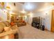 Spacious basement living area with comfortable seating, a mounted television, and carpet floors at 14347 E 134Th Ave, Brighton, CO 80601
