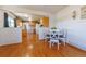 Well-lit dining area with hardwood floors with an opening to the kitchen with white appliances at 14347 E 134Th Ave, Brighton, CO 80601