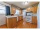 Bright kitchen with wood cabinets, white appliances, and hardwood floors at 14347 E 134Th Ave, Brighton, CO 80601