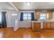 Well-lit kitchen offering wood cabinets, white appliances, and hardwood floors with view to living area at 14347 E 134Th Ave, Brighton, CO 80601