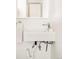Compact bathroom features a wall-mounted sink, modern faucet, and convenient towel ring at 1884 S Ivy St, Denver, CO 80224