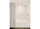 Clean bathroom features white subway tiles, a showerhead, and a stylish striped shower curtain at 1884 S Ivy St, Denver, CO 80224