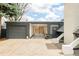 Attached carport and garage with gray doors and adjacent landscape elements at 1884 S Ivy St, Denver, CO 80224