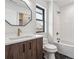 Stylish bathroom featuring a wood vanity, white tile, and a soaking tub at 3289 S Eudora St, Denver, CO 80222