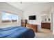 Spacious bedroom with a large window, carpet and view into an en-suite bathroom at 14700 E 104Th Ave # 805, Commerce City, CO 80022