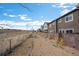 Exterior view along the backside of the property featuring a gravel alleyway and fenced yards at 14700 E 104Th Ave # 805, Commerce City, CO 80022