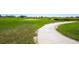 Scenic golf course view with lush green grass and winding concrete path on a sunny day at 14700 E 104Th Ave # 805, Commerce City, CO 80022
