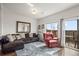 Cozy living room with a large couch, accent chair, and outdoor access at 14700 E 104Th Ave # 805, Commerce City, CO 80022