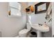 This powder room features a pedestal sink, decorative crate storage, and a mirror at 11303 Vernon Way, Parker, CO 80134