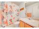 This bathroom has light wood cabinets, a white sink, and a colorful shower curtain at 11303 Vernon Way, Parker, CO 80134