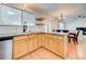 Well-lit kitchen with stainless appliances, maple cabinets, tile countertop, and eat-in dining area at 11303 Vernon Way, Parker, CO 80134