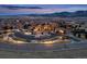 Scenic aerial view of illuminated community buildings at dusk with mountains in the background at 15145 W Washburn Ave, Denver, CO 80228