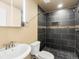 Sleek bathroom with a modern sink, toilet, and a tiled walk-in shower with glass accents at 15145 W Washburn Ave, Denver, CO 80228